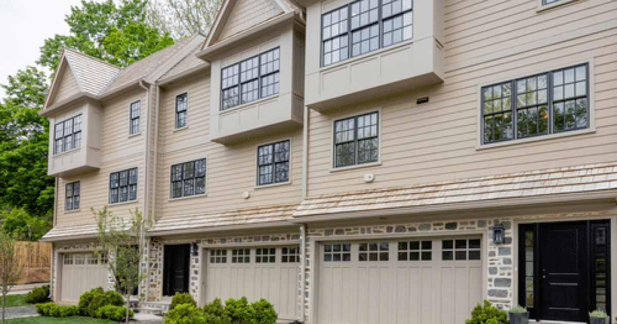 a large tan building with a driveway and trees in Norristown PA